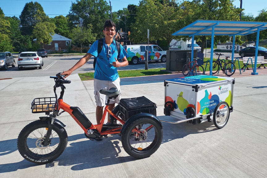 BPL staff member smiles as he stands beside the etrike and trailer