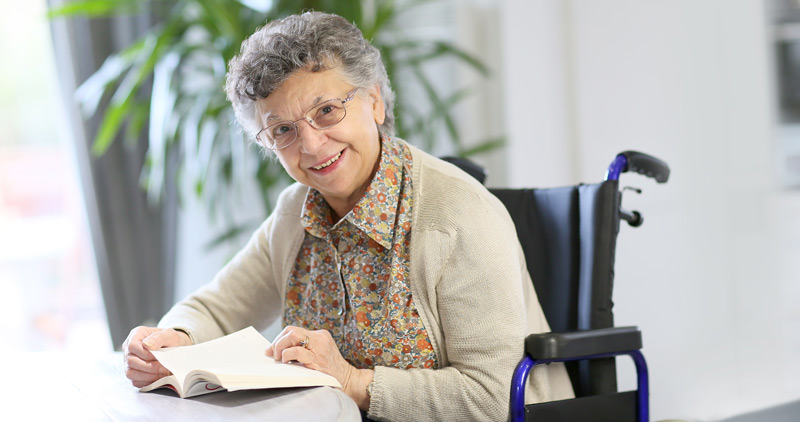 Senior lady smiling with book